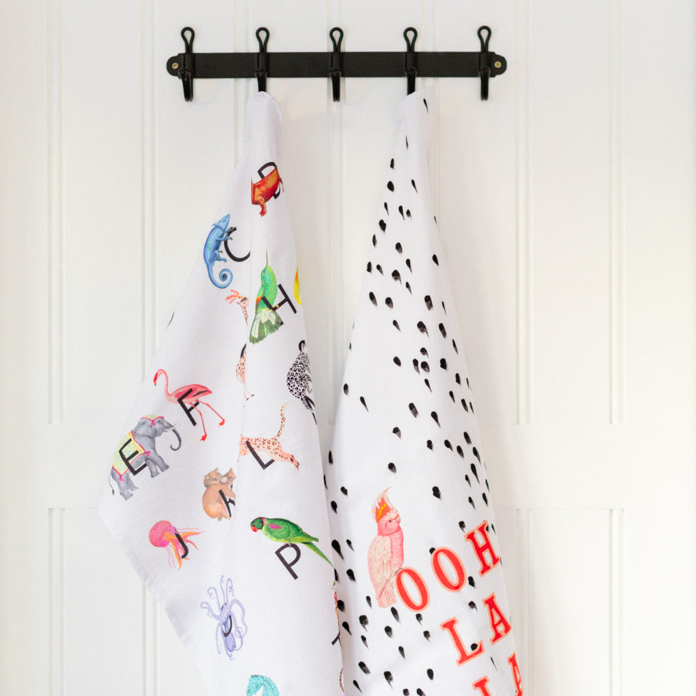 Alphabet and Ooh La La tea towels hanging on hooks